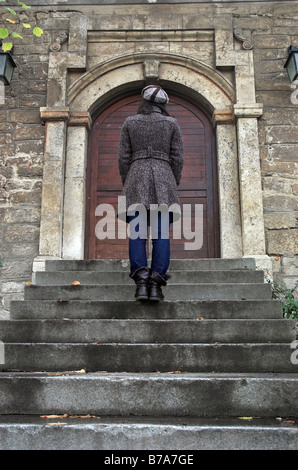 Junge Frau auf der Treppe vor der alten Burg Stockfoto