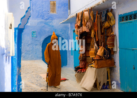 Lokale Einwohner mit Rohrstock vor Ledergeschäft in Chefchaouen, Marokko, Afrika Stockfoto