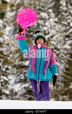 Mädchen 9 Jahre alt mit Schnee-Schieber Stockfoto