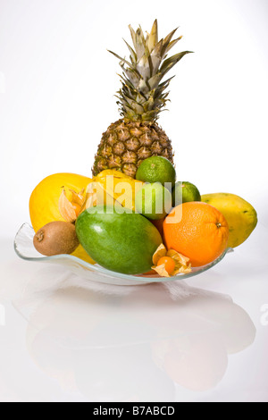 Exotische Früchte in eine Glasschüssel, Ananas, Melonen, Trauben, Orange, Limette, Physalis, Kiwi, Mango, papaya Stockfoto
