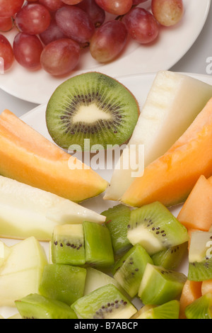 Exotische Früchte auf Platten geschnitten, Zucker, Melone, Honigmelone, Ananas, Kiwi und Trauben Stockfoto