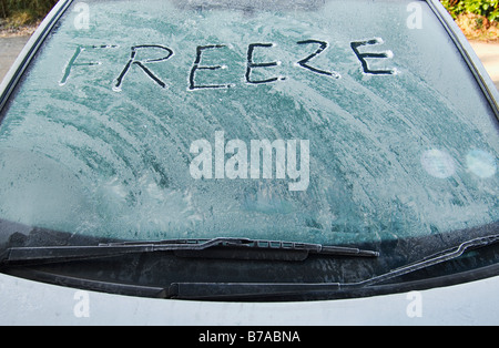 Das Wort "Einfrieren" geschrieben mit einem Finger auf eine frostige und vereisten Windschutzscheibe eines Autos Stockfoto