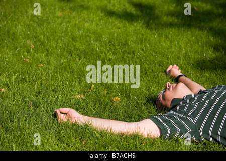 45 Jahre alten Mann genießen Sie die Sonne auf einer Wiese Stockfoto