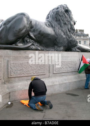 VEREINIGTES KÖNIGREICH. Muslimischen Mann, der betet während der Kundgebung gegen die israelische Invasion des Gazastreifens in Trafalgar Sq. in London. Foto von Julio Etchart Stockfoto