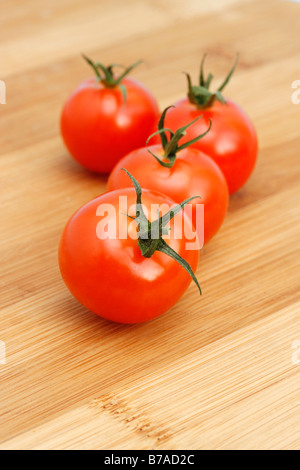 Cocktail-Tomaten (Solanum Lycopersicum) auf einem Holzbrett Stockfoto