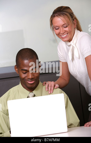 Mann und Frau lächelnd hinunter auf computer Stockfoto