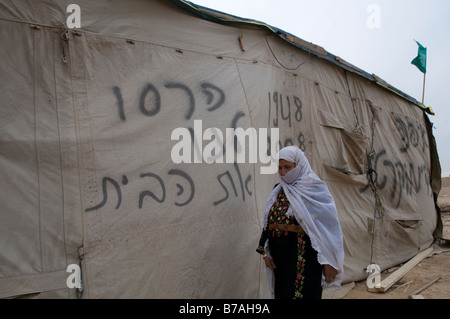 Beduinen Frau mit gesprüht Hebräischen Satz, der lautet: "Unser Haus abgerissen wurde, 'Ein unbekanntes Bedouin Village in der Wüste Negev Israel Stockfoto