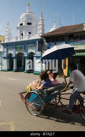 Touristen auf eine Rikscha vor der muslimischen indischen Nagore Durgha Sherif in Georgetown, Penang Island, Malaysia Stockfoto