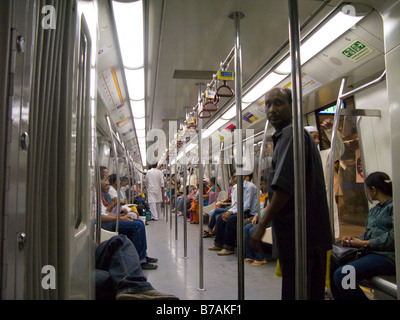 Eine gelbe Linie Rohr Zug Wagen Innenraum mit Passagieren. Delhi Metro Rail System. Delhi, Indien. Stockfoto