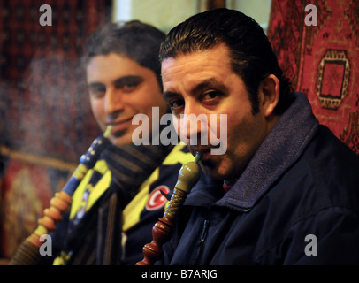 Zwei türkische Männer sitzen zusammen Rauchen traditionellen Wasserpfeifen (Shisha/Nargile) in einem Innenhof im Eminonu, Istanbul. Stockfoto