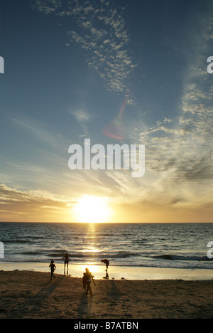 Menschen spielen im Sommer Sonnenuntergang über Glenelg Beach, Adelaide, South Australia. Stockfoto