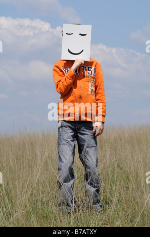 Junge im Feld Holding Smiley-Gesicht Stockfoto