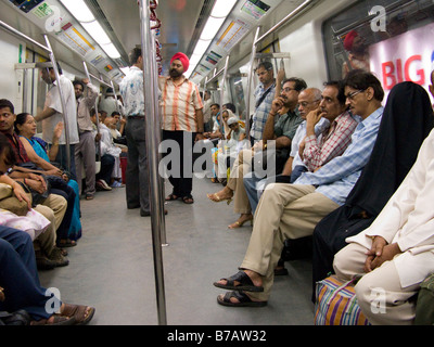 Eine gelbe Linie Rohr Zug Wagen Innenraum mit Passagieren. Delhi Metro Rail System. Delhi, Indien. Stockfoto