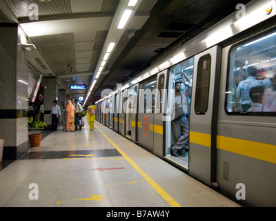 Eine gelbe Linie Zug Kutsche mit offenen Türen auf eine Plattform auf der Delhi Metro Rail System. Delhi. Indien. Stockfoto