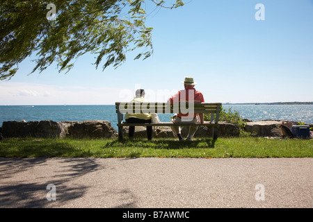 Älteres Paar auf Bank von See Ontario Stockfoto