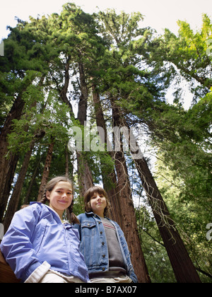 Porträt von Mädchen und jungen vor Mammutbäume, Muir Woods National Monument, Kalifornien, USA Stockfoto