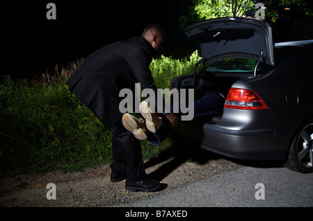 Mann, der Körper im Kofferraum des Autos Stockfoto