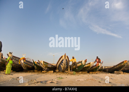 Bunt bemalten Fischerboote säumen den Strand an diesem Fischmarkt in Dakar, Senegal. Stockfoto