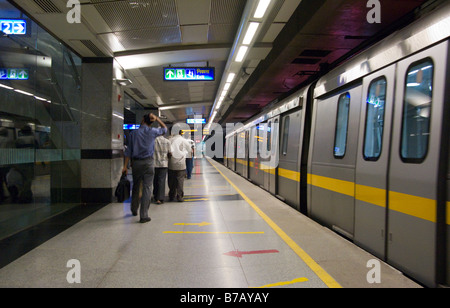 Eine gelbe Linie Zug an der Plattform & einige Passagiere an Chandni Chowk Station auf der Delhi Metro Rail-System. Delhi. Indien. Stockfoto