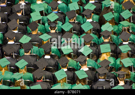 Schülerinnen und Schüler in Kappen und Kleider freuen uns auf zukünftige nach dem Studium. Stockfoto