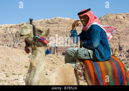 Jungen Beduinen Mann reitet ein Kamel in Petra in Jordanien Stockfoto