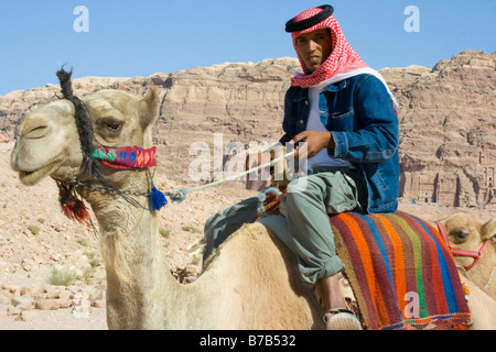 Jungen Beduinen Mann reitet ein Kamel in Petra in Jordanien Stockfoto