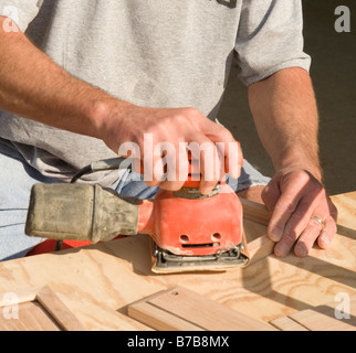 die Hand eines Mannes mit einer elektrischen Sander auf eine Holz-Projekt. Stockfoto