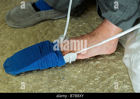 Mit Hilfe einer Socke oder Strumpf Hilfe für Dressing nach einer Hüft-Operation oder andere Bedingungen beim Biegen ist nicht gestattet. Stockfoto