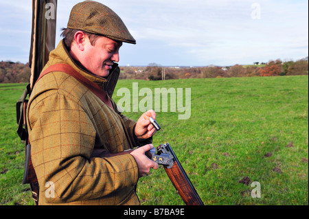 Mann eine Schrotflinte auf einem angetriebenen Shooting-Tag in der britischen Landschaft laden Stockfoto