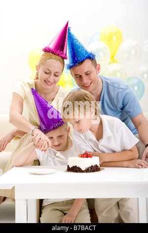 Porträt der Familie schneiden Geburtstag Kuchen lächelnd Stockfoto