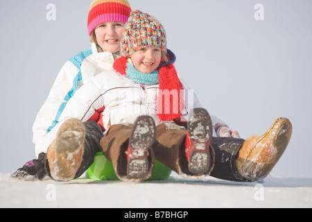 13 und 9 Jahre alten Kindern Rutsche bergab, Winnipeg, Kanada Stockfoto