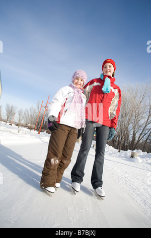 Porträt von 9 und 13 Jahre alten Mädchen in Schlittschuhe, The Forks, Winnipeg, Kanada Stockfoto