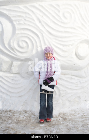 9 - Jahre altes Mädchen mit Skates neben Schnee Skulptur, The Forks, Winnipeg, Kanada Stockfoto