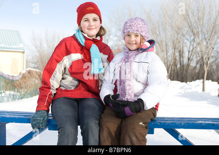9 und 13 Jahre alten Mädchen auf Bank, skating Loipen, The Forks, Winnipeg, Kanada Stockfoto