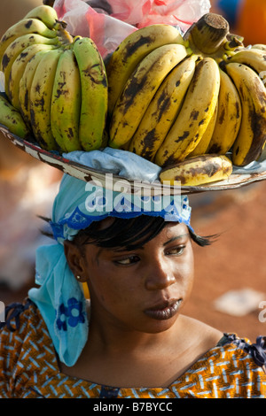 Junge Frau trägt Bananen zu verkaufen auf dem Kopf in Bamako, Mali Stockfoto