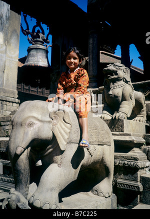 Eine NEPALESISCHE Mädchen reitet einen Elefanten auf den Stufen des Tempels RAMESHWAR in BHAKTAPUR S DURBAR SQUARE NEPAL Stockfoto