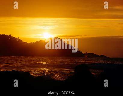 Die Sonne versinkt hinter POINT LOBOS STATE PARK in der MONTEREY BAY Heiligtum CARMEL CALIFORNIA Stockfoto