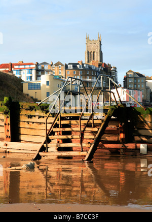 Steighilfen über eine Mole mit Strandpromenade Gebäuden und Kirchturm im Hintergrund bei Cromer, Norfolk, Großbritannien. Stockfoto