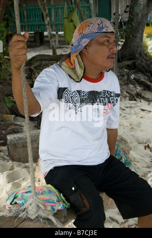 Mann, sitzend auf Schaukel, Dumaluan Beach Resort, Panglao Island, Bohol, Visayas, Philippinen Stockfoto