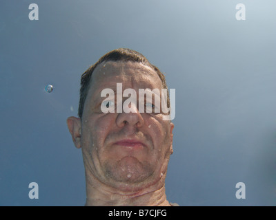 Das Gesicht des Mannes durch Anzeigen von Unterwasser verzerrt Stockfoto