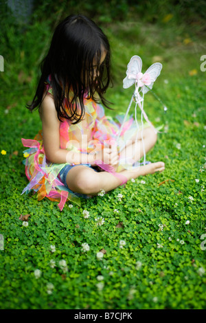 Fünf Jahre altes Mädchen im Garten in ihr Spiel Kleidung gekleidet Stockfoto