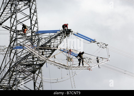 Arbeiter an den Isolatoren an einem Hochspannungsmast, Deutschland, Nordrhein-Westfalen Stockfoto