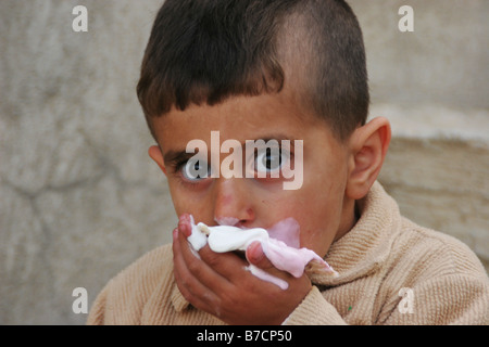 Kurdische junge essen Eis und mit schmutzigen Hände Reinigung seiner Südkorfu Sulaymaniyah, Sulaimaniyya, Irakisch-Kurdistan, Irak Stockfoto