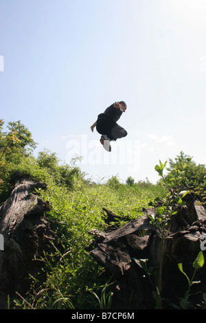 Parkour-Sportler auf einen gewagten Sprung über natürliche Hindernisse, Österreich, Wien, Donauinsel Stockfoto