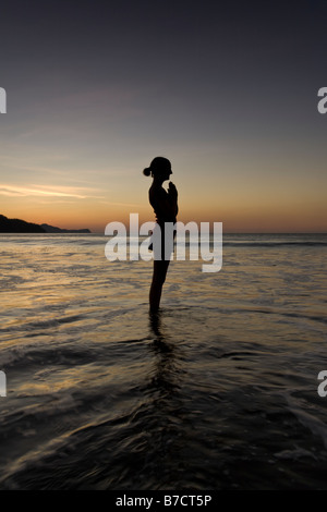 Silhouette der jungen Frau in Playas del Coco, Costa Rica Yoga am Strand bei Sonnenuntergang zu machen. Stockfoto