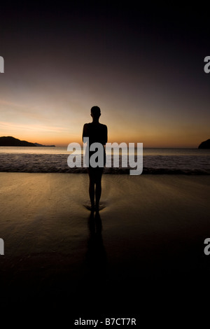 Silhouette der jungen Frau in Playas del Coco, Costa Rica Yoga am Strand bei Sonnenuntergang zu machen. Stockfoto