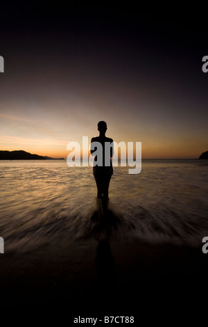 Silhouette der jungen Frau in Playas del Coco, Costa Rica Yoga am Strand bei Sonnenuntergang zu machen. Stockfoto