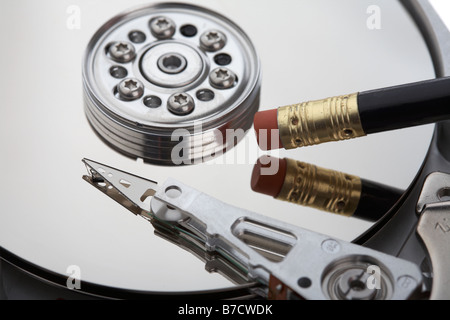 Radiergummi am Ende eines Bleistifts Reiben auf der Platte mit einem Computer Festplatte Daten Ausbau Zerstörung löschen Konzept ändern Stockfoto