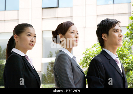 Drei Geschäftsleute in einer Reihe stehen und blickte Seitenansicht anzeigen Stockfoto