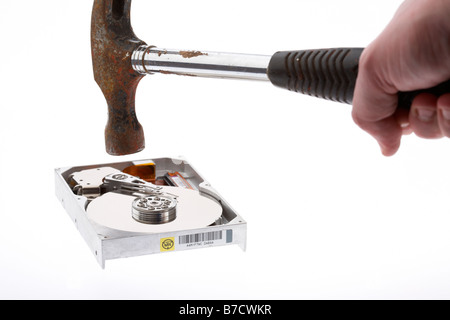 Mans Hand, die alten Hammer gegenüber einer Computer-Festplatte auf weißem Hintergrund Stockfoto